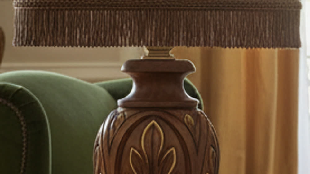 Close-up of the carved walnut body with gold-leaf finish and of the shade trimming