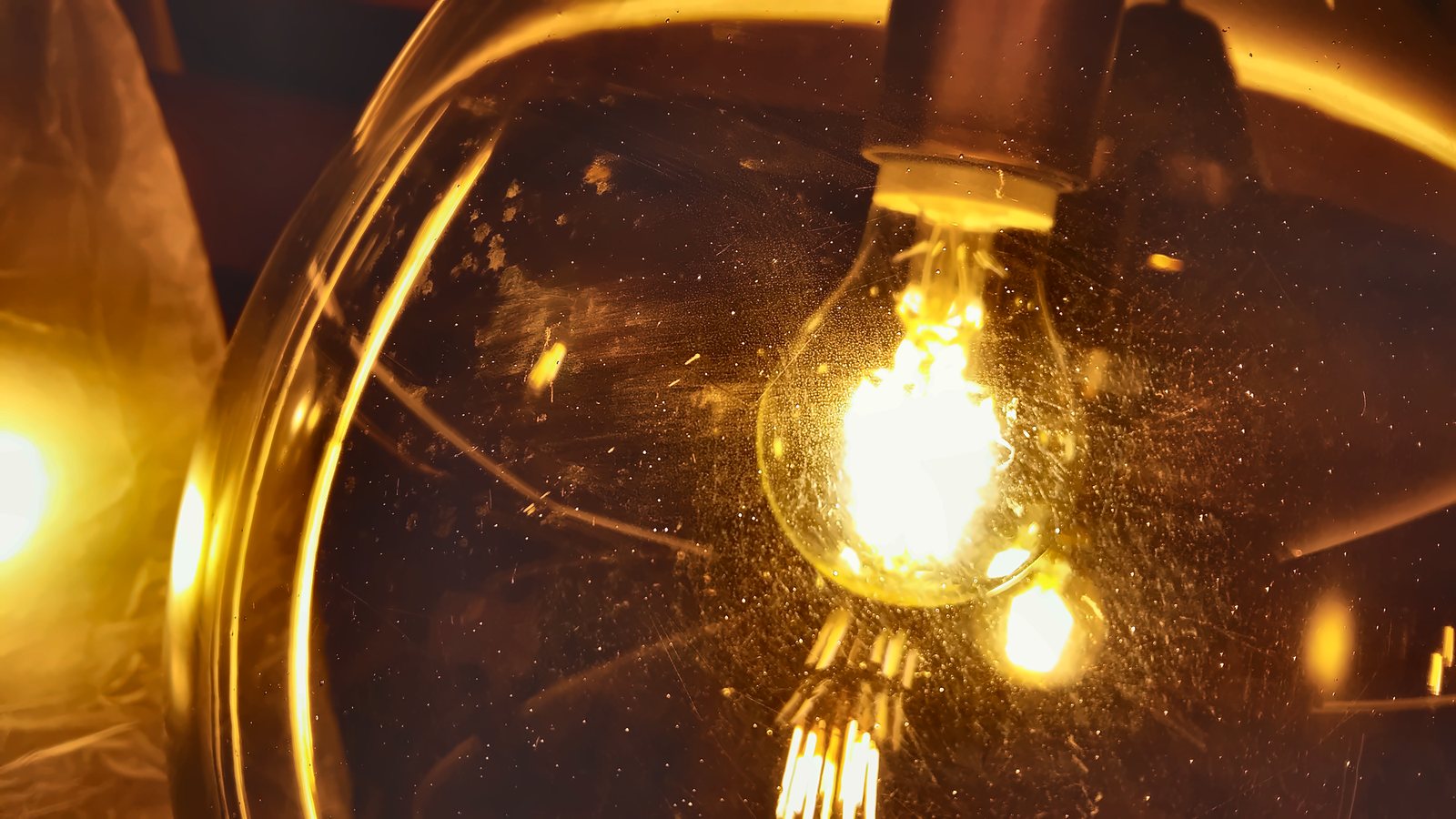 The filament bulb inside the smoked glass globe, seen up close