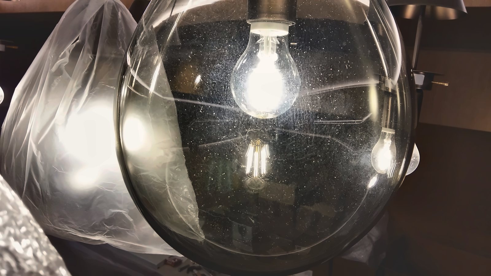 Clear glass globe with a filament bulb, still behind the site protection sheet