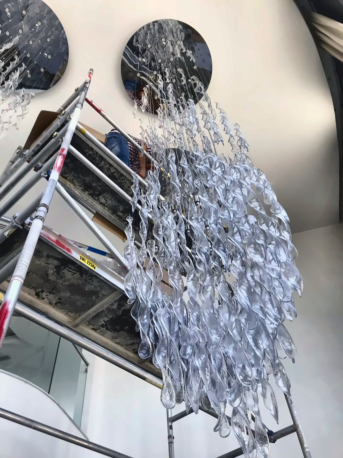La cascade en montage sur l'échafaudage, les rubans de verre accrochés un à un