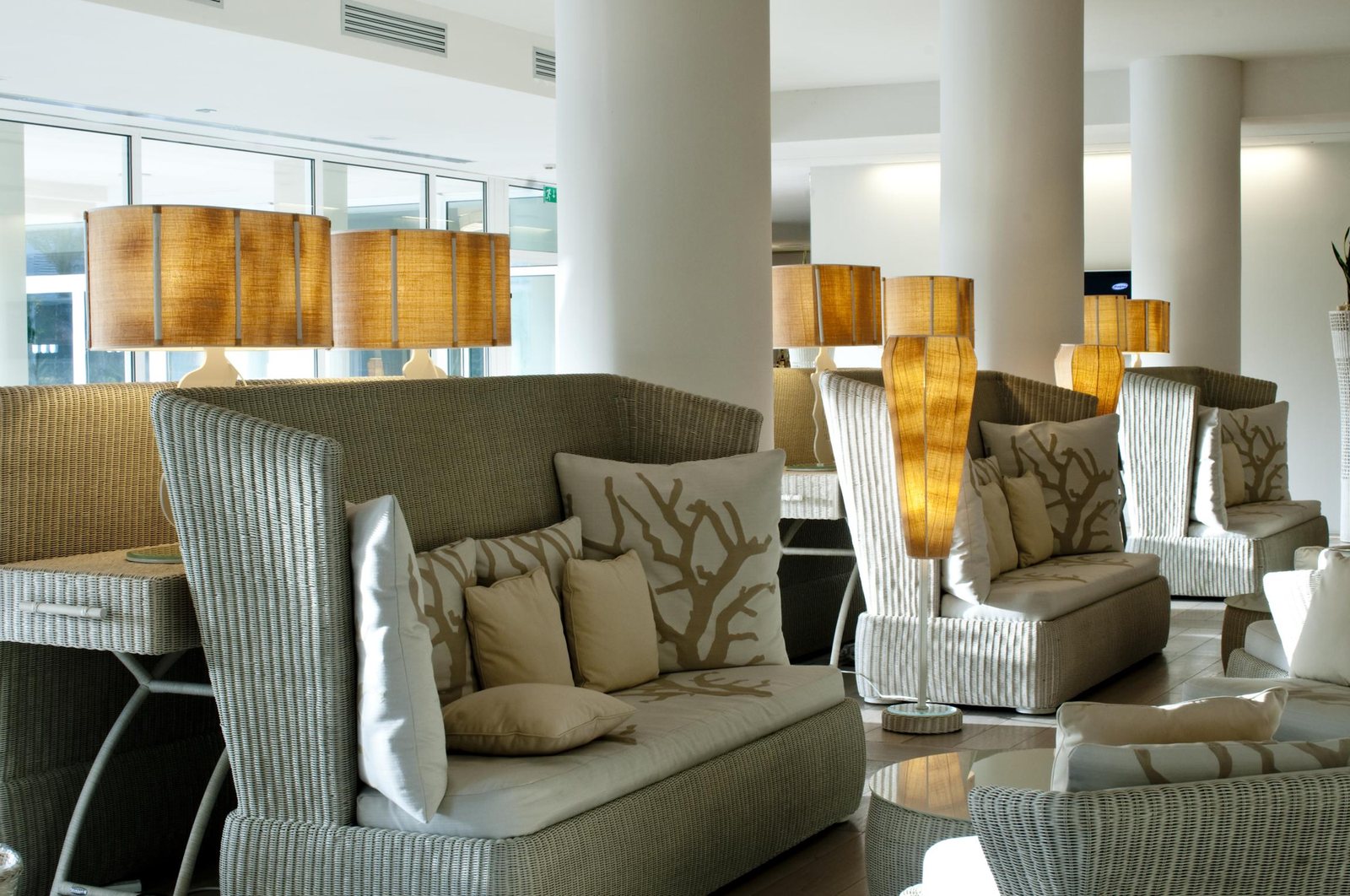 The lobby with wicker sofas and natural fabric shades, drum-shaped in front and tapered behind