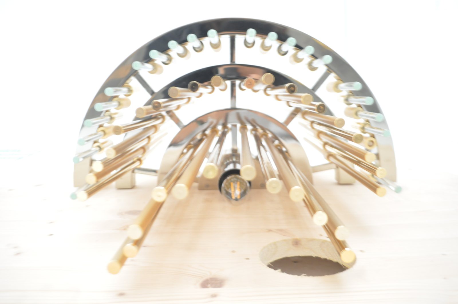 The bare structure on the bench: the radial arms and lamp holders, before the rods