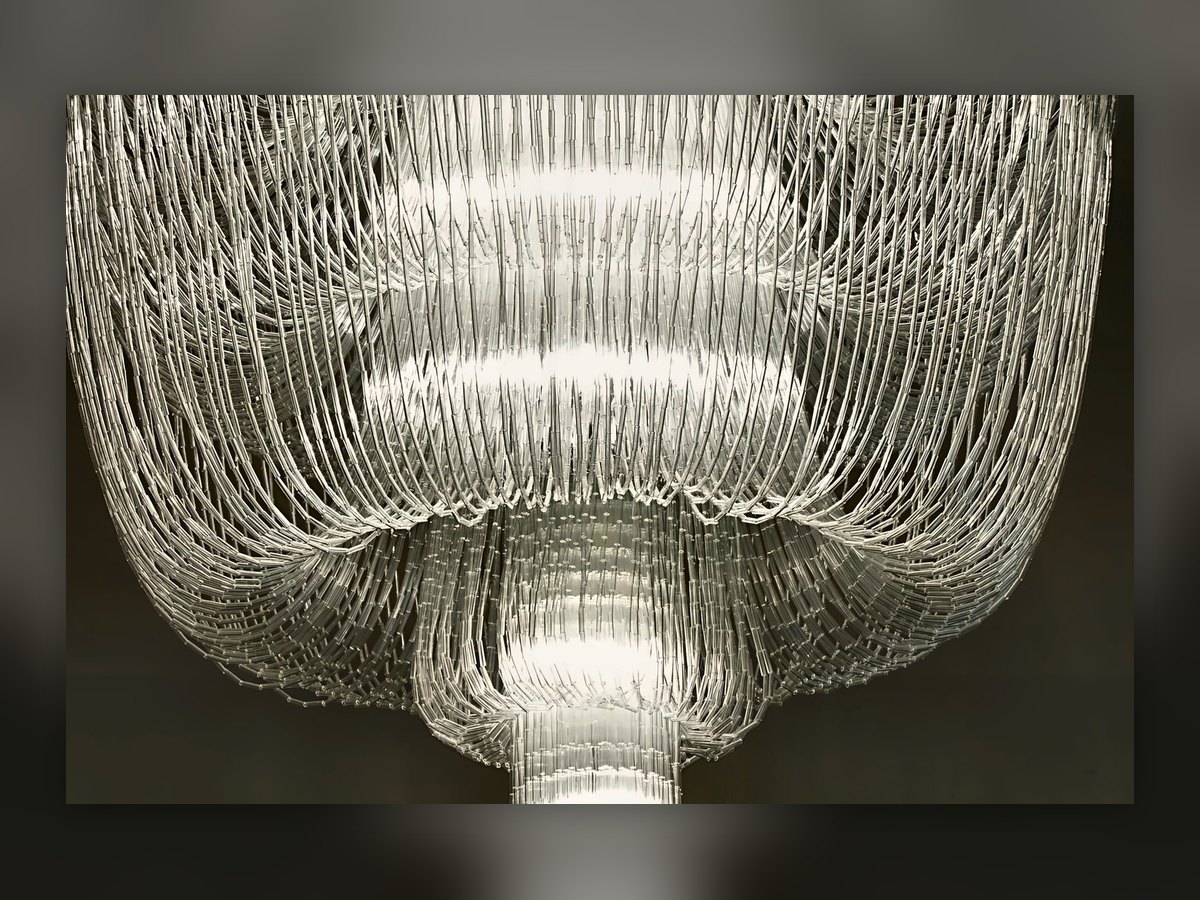 The tiered glass-cane chandelier in the Villa Le Maschere dining room, lit