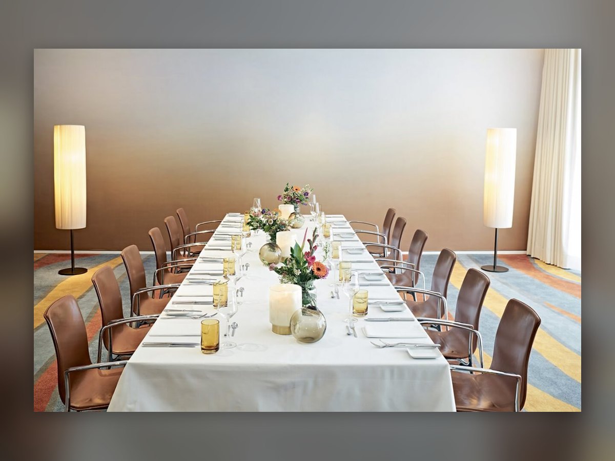 Two cylindrical pleated floor lamps flanking the long table in the SIDE Hotel private dining room