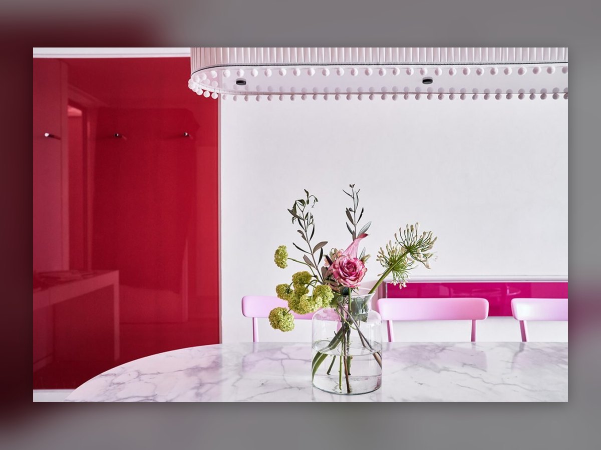 The row of small cylindrical pendants along the ceiling of the pink room, above the marble table