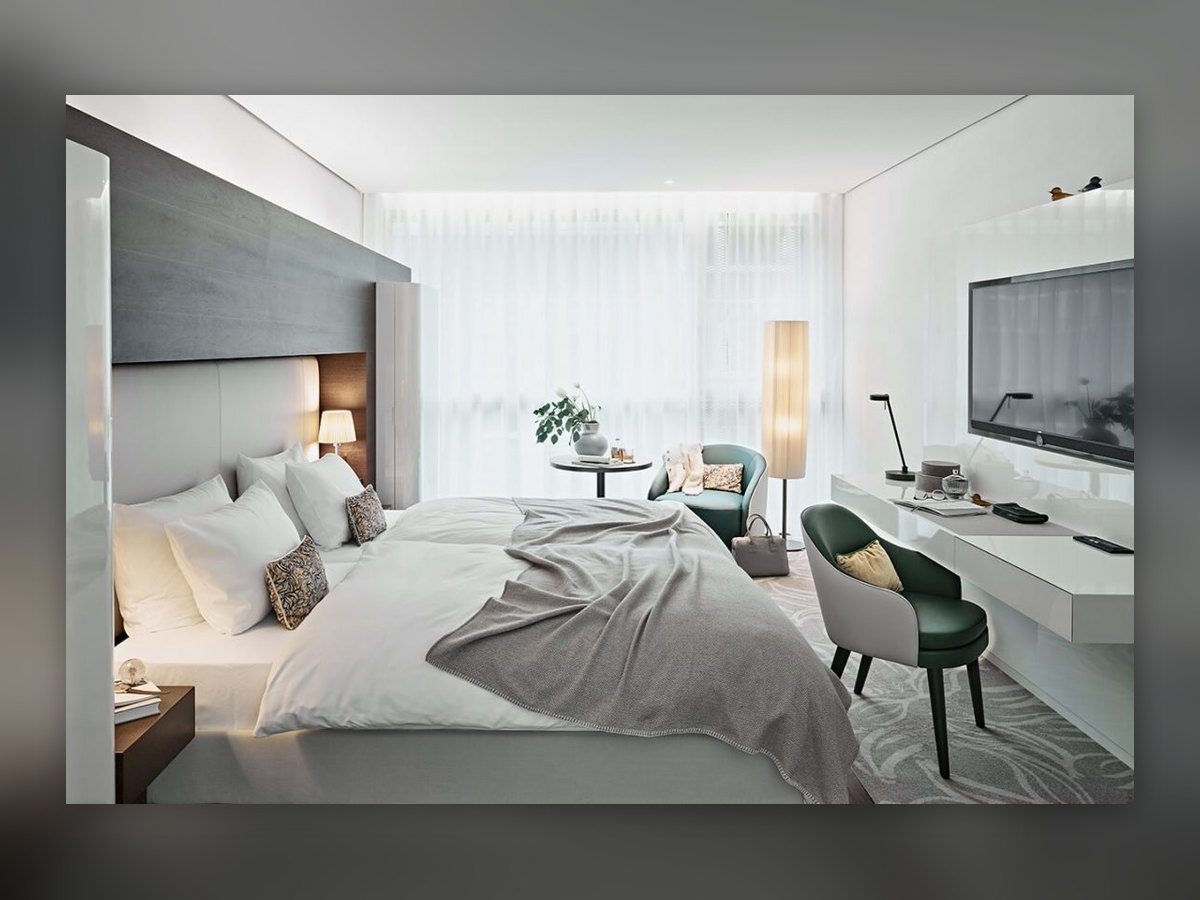 Cylindrical floor lamp beside the side table, in the room with the green armchair and desk