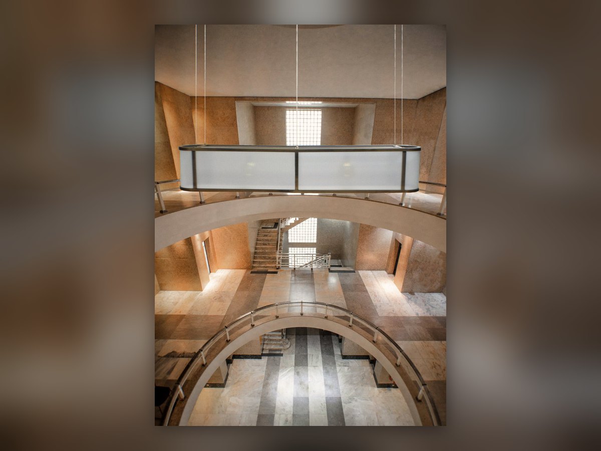 Ambient rendering of the oval fitting hung in a double-height stone hall
