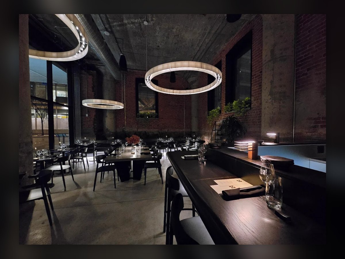 The NAMA dining room in the evening, rings lit above the laid tables