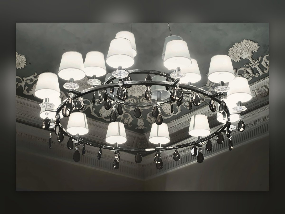 Ring chandelier with fabric shades and crystal drops, under the decorated ceiling