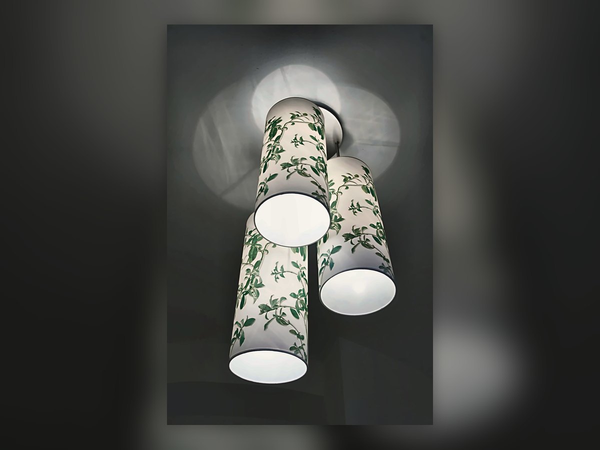 Three botanical-print fabric cylinders hung at different heights
