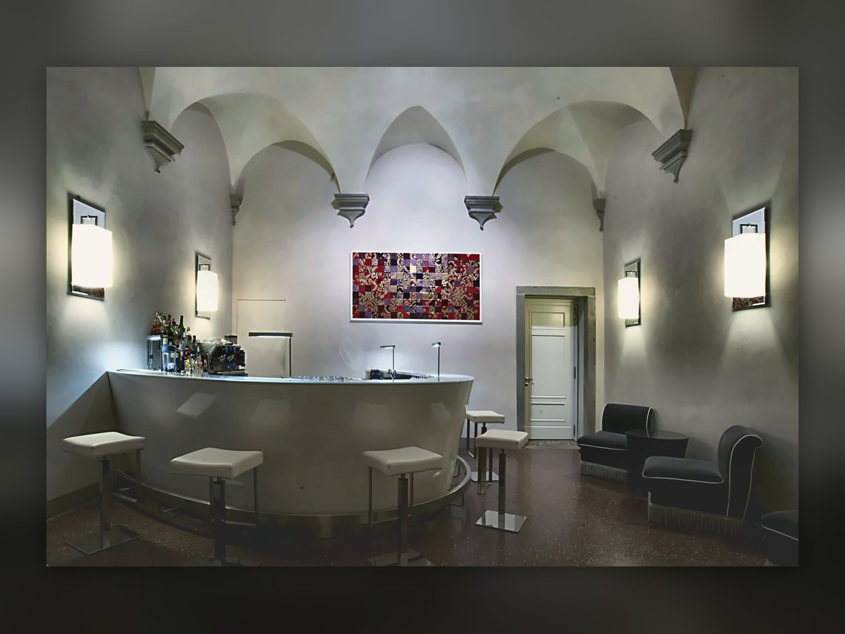 The Villa Le Maschere bar under the vaults, with square wall lights