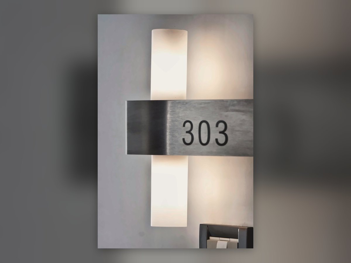 Room number 303 on a backlit wall column