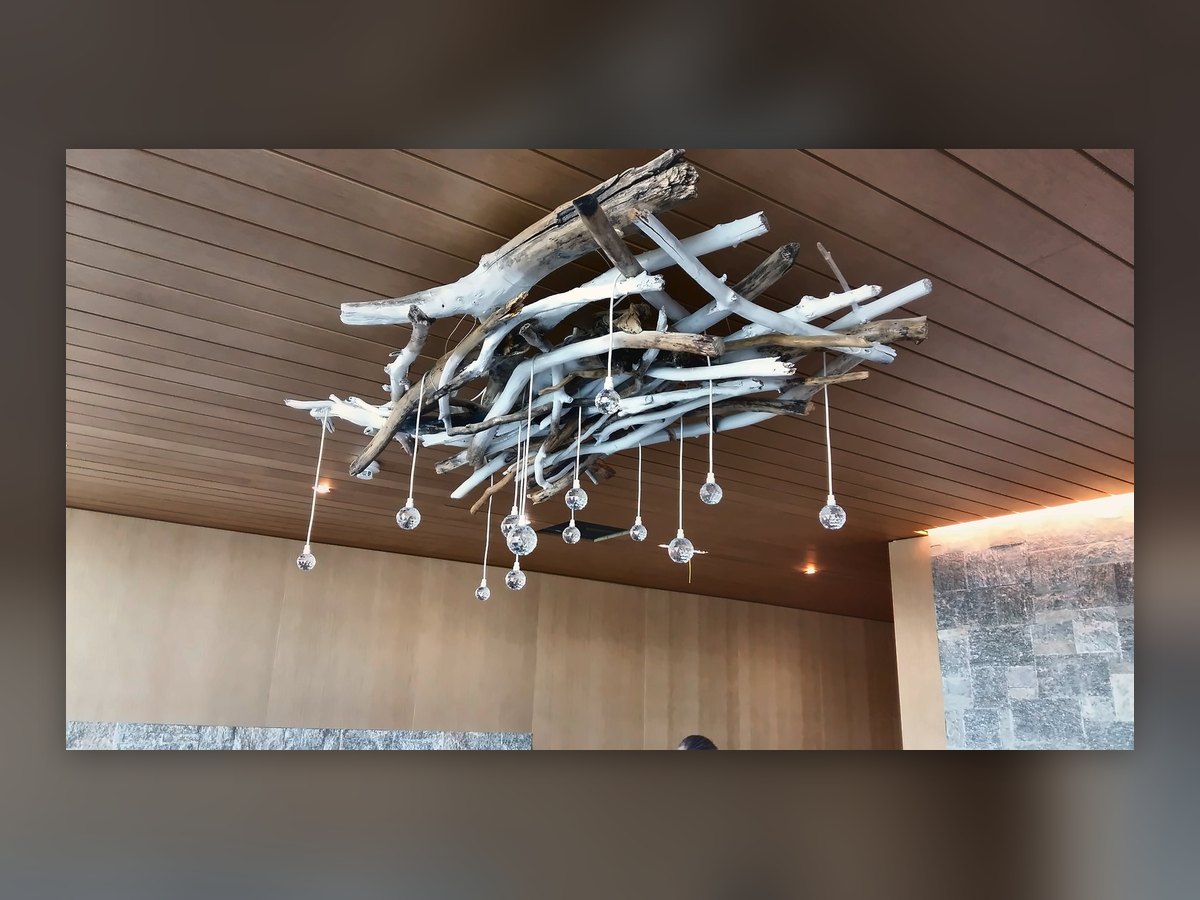 The cluster of glass drops hung from a branch structure, on the Alpine Spa's timber ceiling