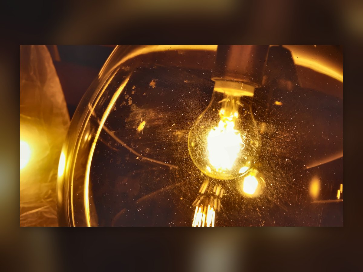 The filament bulb inside the smoked glass globe, seen up close