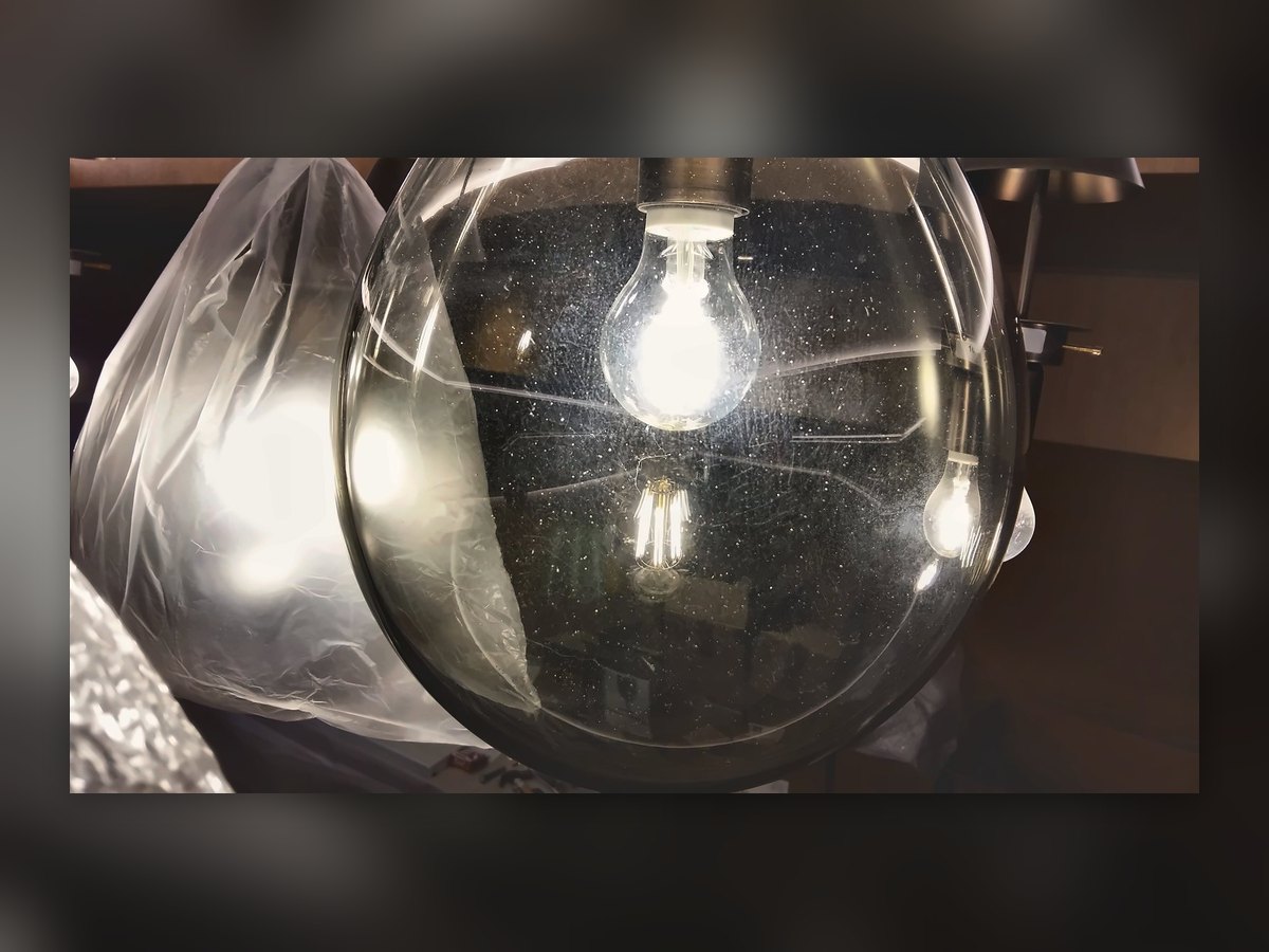 Clear glass globe with a filament bulb, still behind the site protection sheet