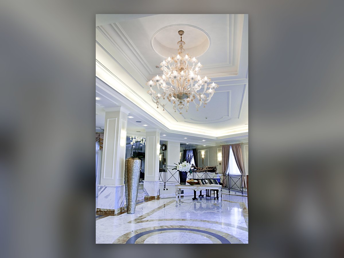 The lobby: the chandelier under the ceiling medallion, above the rosette inlaid in the marble floor