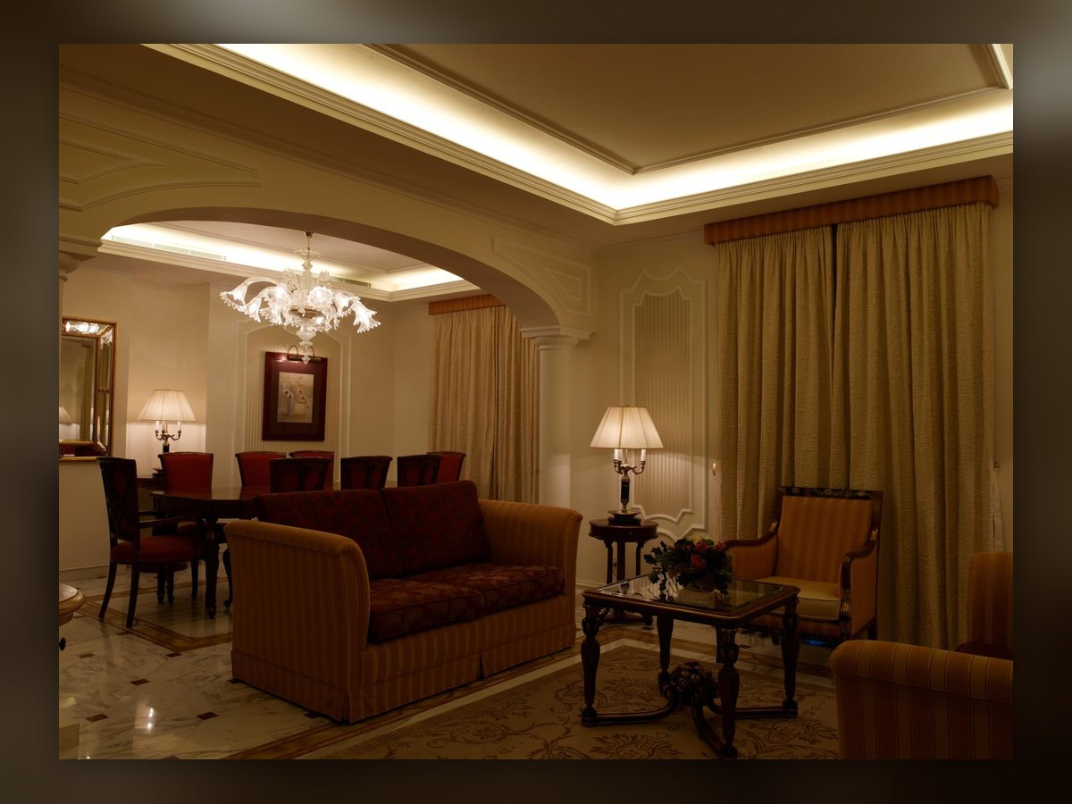 The suite living room, with the chandelier in the far arch and the table lamp lit on the side table