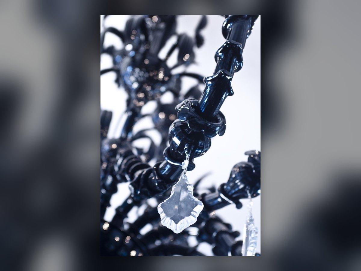 The black glass arms close up, with a clear crystal drop hanging from them