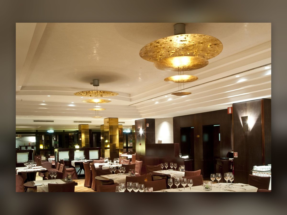 The restaurant laid for service, with the gilded discs suspended below the ceiling