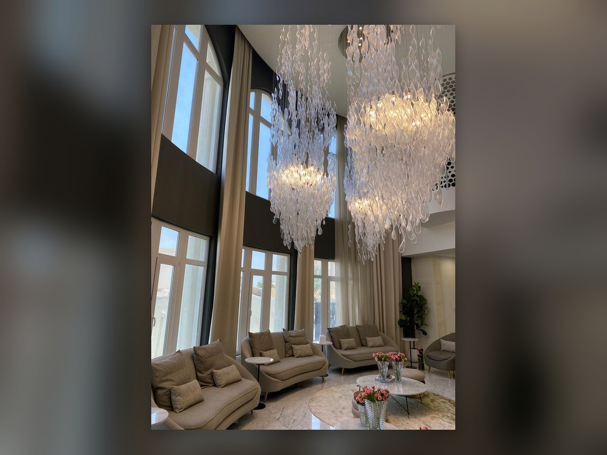 The double-height salon with the glass cascades hung in front of the windows