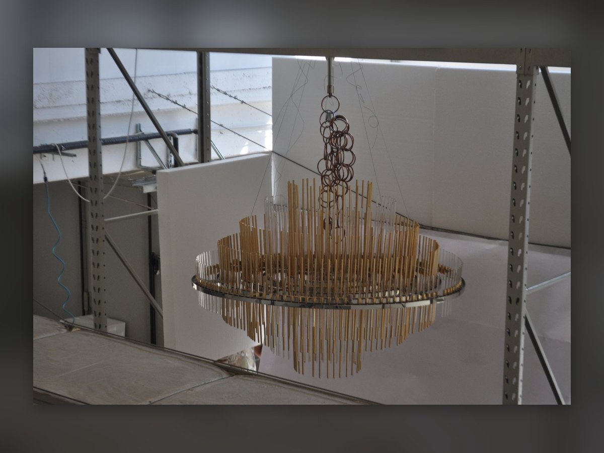 The chandelier hung in the workshop for testing, in front of a white backdrop