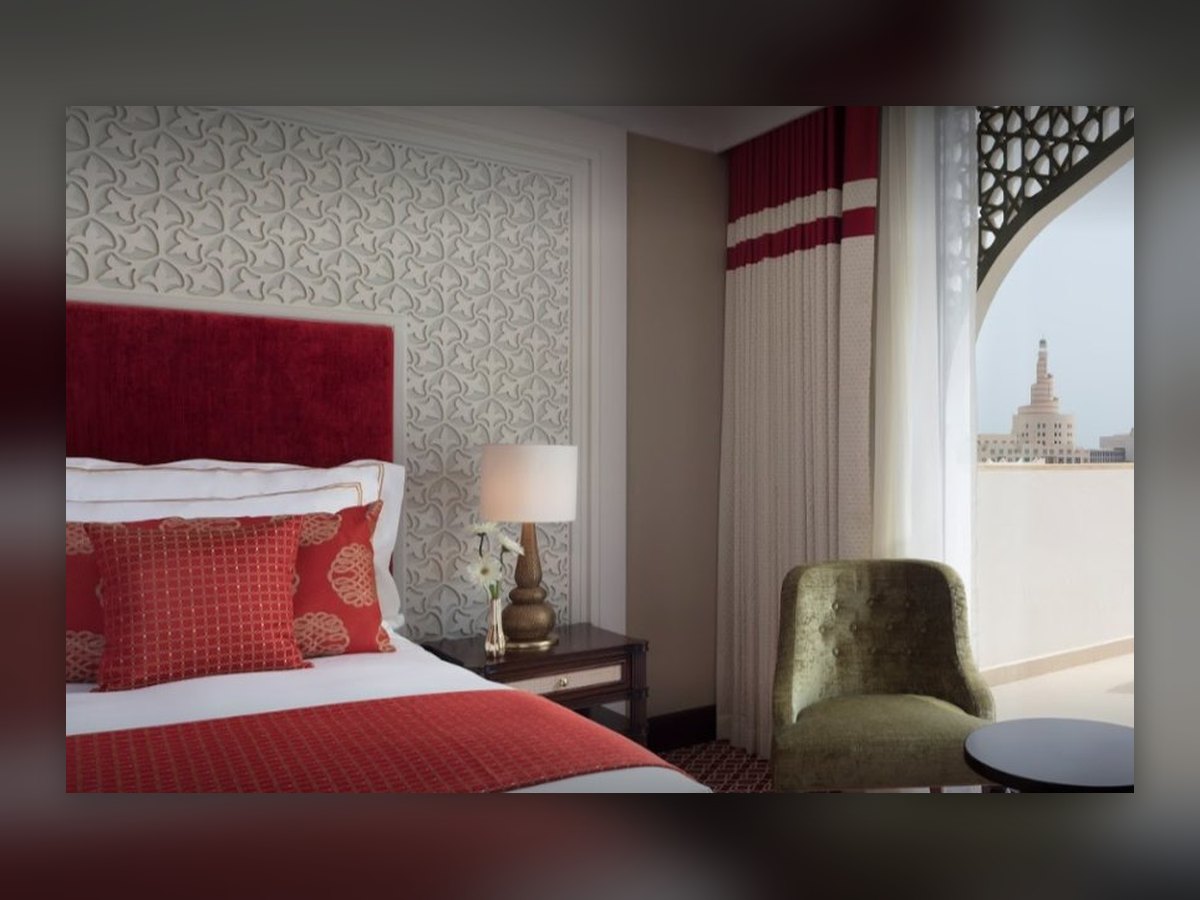 The guest room with its red headboard and, through the window, the spiral tower