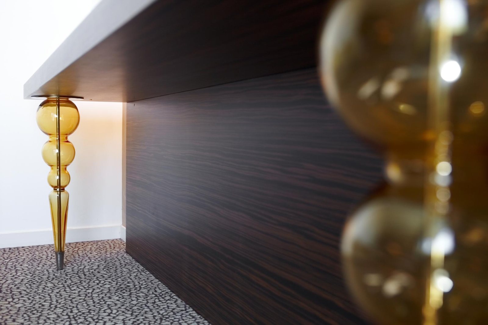 Detail eines Zimmers im Antony Palace Hotel: das Bein aus bernsteinfarbenen mundgeblasenen Glaskugeln unter der Schreibtischplatte