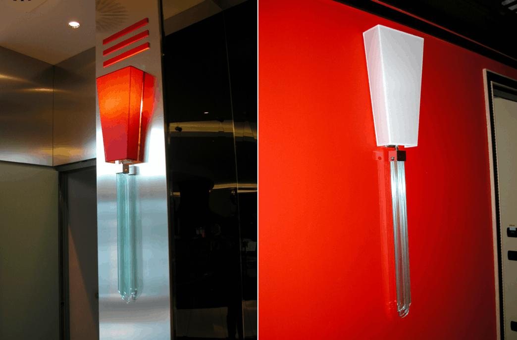 Die Wandleuchte des UNA Hotel Malpensa in zwei Ansichten: roter Schirm am metallverkleideten Pfeiler, weißer an der roten Wand, Behang aus Kristallrauten