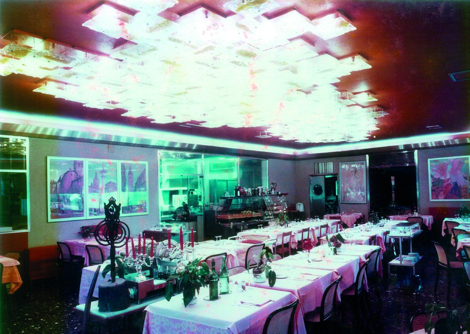 Das Restaurant des Russott Hotel zur Zeit des Hotel Ramada: eine leuchtende Komposition aus klaren und bernsteinfarbenen Glasfliesen an der Decke, über Tischen mit rosa Tischdecken