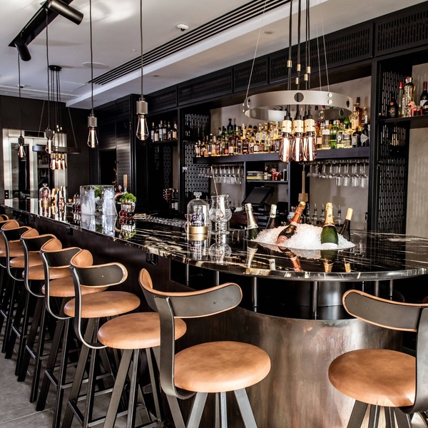 Buster & Punch Hero Light chandelier above a bar counter